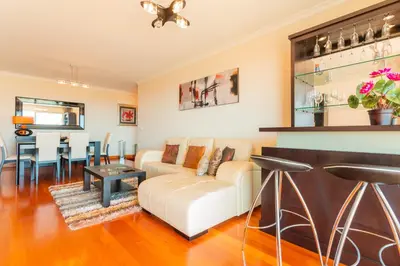 a living room with a couch and a bar at FLH Funchal Green Park Apartment with Pool in Funchal
