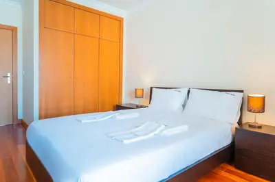 a bedroom with a white bed with two white towels on it at FLH Funchal Green Park Apartment with Pool in Funchal