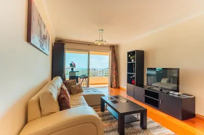 a living room with a couch and a tv at FLH Funchal Green Park Apartment with Pool in Funchal