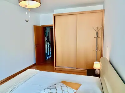 a bedroom with a bed and a closet at Sunny Little Sister Apartment - 7 min walking from the beach and at 7 min driving from the Airport in Machico