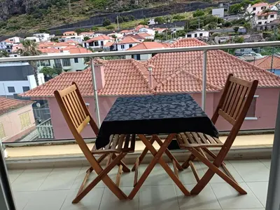 a table and two chairs sitting on a balcony at Sunny Little Sister Apartment - 7 min walking from the beach and at 7 min driving from the Airport in Machico