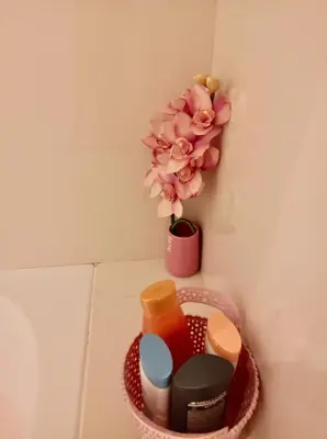 a basket with cosmetics and a flower on a wall at Sunny Little Sister Apartment - 7 min walking from the beach and at 7 min driving from the Airport in Machico