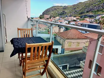 a table and chairs on a balcony with a view at Sunny Little Sister Apartment - 7 min walking from the beach and at 7 min driving from the Airport in Machico