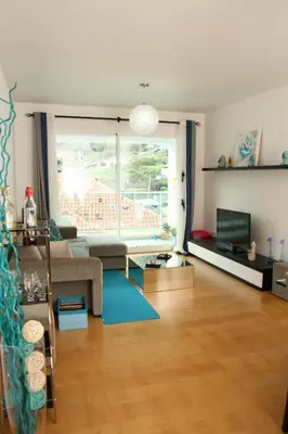 a living room with a couch and a large window at Sunny Little Sister Apartment - 7 min walking from the beach and at 7 min driving from the Airport in Machico
