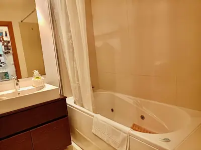 a bathroom with a bath tub and a sink at Sunny Little Sister Apartment - 7 min walking from the beach and at 7 min driving from the Airport in Machico