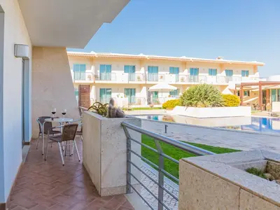 a balcony with a table and chairs and a building at Pontalaia Apartamentos Turísticos in Sagres