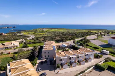 an aerial view of a building with the ocean in the background at Pontalaia Apartamentos Turísticos in Sagres