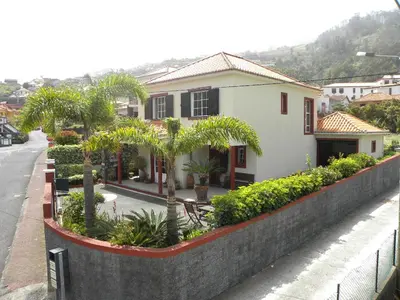 a house with trees and plants in front of a street at Moradia Ponte de Pedra in São Vicente