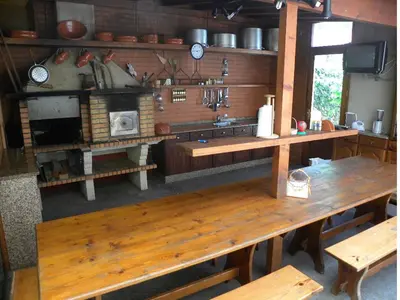 a kitchen with a wooden table and a stove at Moradia Ponte de Pedra in São Vicente