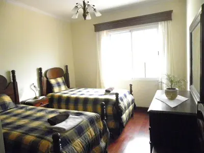 a hotel room with two beds and a window at Moradia Ponte de Pedra in São Vicente