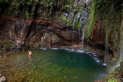 a man standing in a pool of water in a cave at Moradia Ponte de Pedra in São Vicente