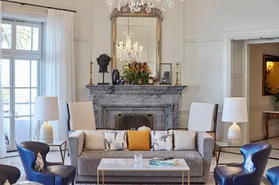 a living room with a couch and a fireplace at Reid's Palace, A Belmond Hotel, Madeira in Funchal