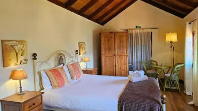 a bedroom with a large white bed in a room at Refúgio da Ribeira in Porto Moniz