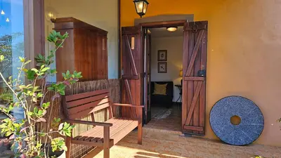 a wooden bench sitting outside of a house at Refúgio da Ribeira in Porto Moniz