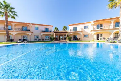 a large swimming pool in front of a building at Atalaia Sol Aparthotel - tennis & heated pool in winter in Lagos