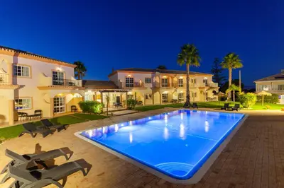 a large swimming pool in front of a house at Atalaia Sol Aparthotel - tennis & heated pool in winter in Lagos