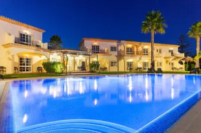 a large swimming pool in front of a house at Atalaia Sol Aparthotel - tennis & heated pool in winter in Lagos