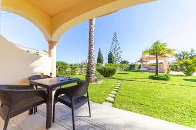 a patio with a table and chairs and a yard at Atalaia Sol Aparthotel - tennis & heated pool in winter in Lagos