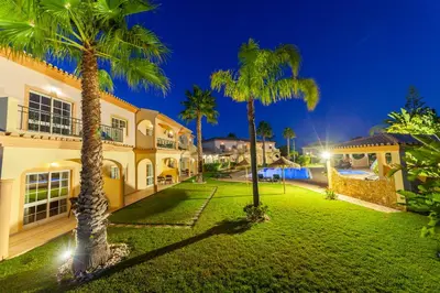 an exterior view of a house with palm trees at Atalaia Sol Aparthotel - tennis & heated pool in winter in Lagos