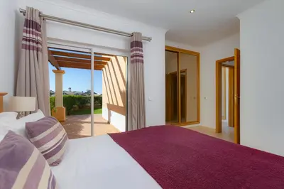 a bedroom with a large bed and a balcony at The View – Santo António Villas, Golf & Spa in Salema