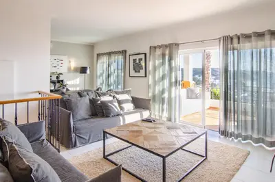 a living room with a couch and a glass table at The View – Santo António Villas, Golf & Spa in Salema