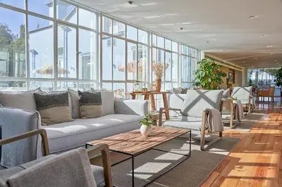 a living room with a couch and tables and windows at PortoBay Serra Golf in Santo da Serra