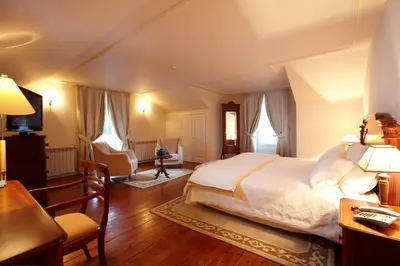 a bedroom with a bed and a table and chairs at PortoBay Serra Golf in Santo da Serra