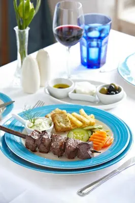 a plate of food with meat and vegetables on a table at PortoBay Serra Golf in Santo da Serra