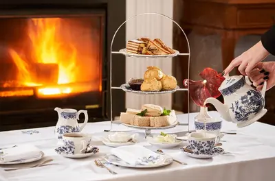 a table with a tea party with a cake and tea cups at PortoBay Serra Golf in Santo da Serra