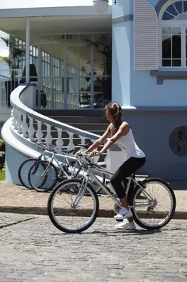 a woman is riding a bike on the street at PortoBay Serra Golf in Santo da Serra