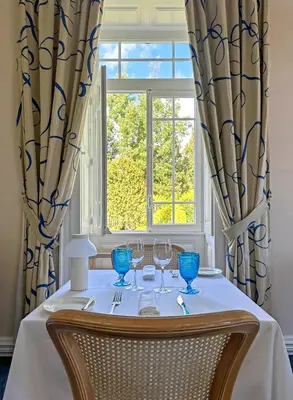 a table with wine glasses and a window at PortoBay Serra Golf in Santo da Serra