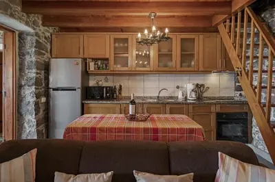 a kitchen with a table with a bottle of wine at Refúgio da Serra - By WeHost in Arco da Calheta