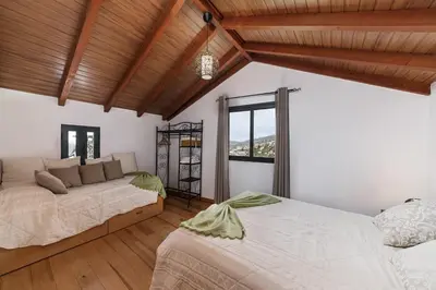 a bedroom with two beds and a large window at Refúgio da Serra - By WeHost in Arco da Calheta