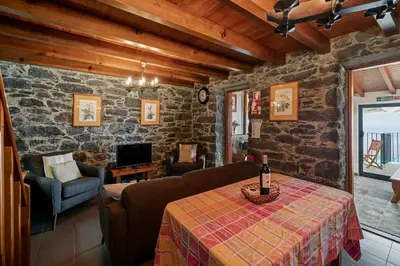 a living room with a table with a bottle of wine at Refúgio da Serra - By WeHost in Arco da Calheta
