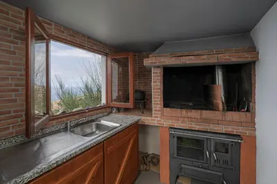 a kitchen with a sink and a brick wall at Refúgio da Serra - By WeHost in Arco da Calheta