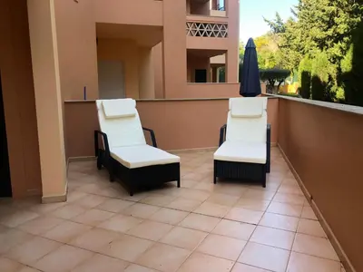 two chairs and an umbrella on a balcony at Rother Praia da Luz Luxury Apartment in Luz