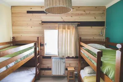 a bedroom with two bunk beds and a window at Good Feeling Hostel & Guest House in Raposeira