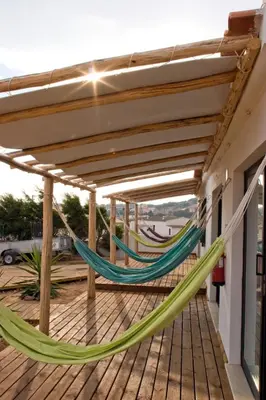 a couple of hammocks on a deck at Good Feeling Hostel & Guest House in Raposeira
