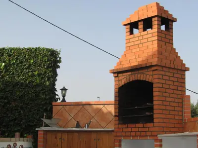 a brick chimney with an oven in front of a building at Good Feeling Hostel & Guest House in Raposeira