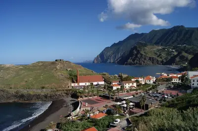 a town on a hill next to the ocean at Hotel Costa Linda in Porto da Cruz