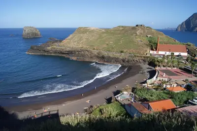 a view of a beach next to the ocean at Hotel Costa Linda in Porto da Cruz