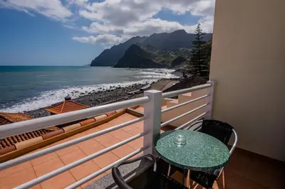 a balcony with a table and a view of the beach at Hotel Costa Linda in Porto da Cruz