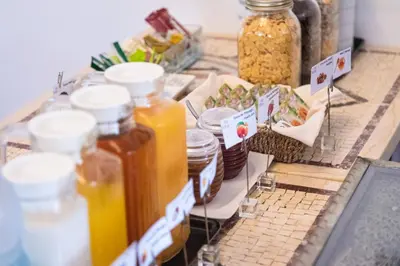 a table topped with jars of honey and food at Hotel Vale Da Telha in Aljezur