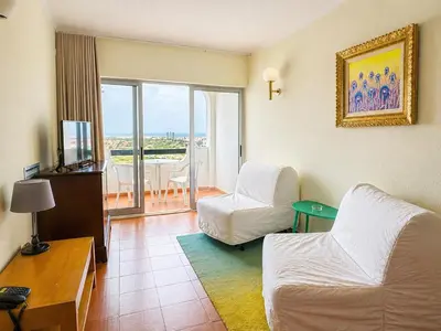 a kitchen with two stools and a counter with a microwave at Aparthotel Navigator in Sagres