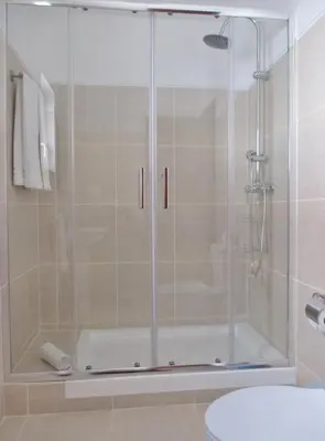 a shower with a glass door in a bathroom at Apartamentos Salema Praia Club in Salema