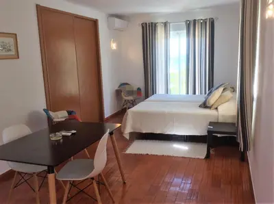 a bedroom with a bed and a table and chairs at Apartamentos Salema Praia Club in Salema
