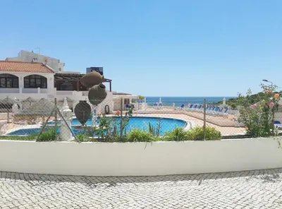 a view of a swimming pool and the ocean at Apartamentos Salema Praia Club in Salema
