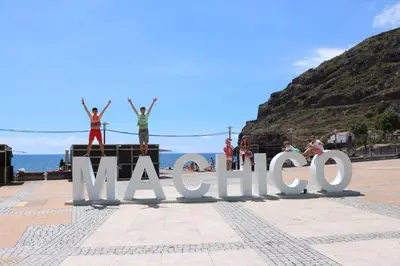 a group of people standing on top of the madonna sign at Grannies House in Machico