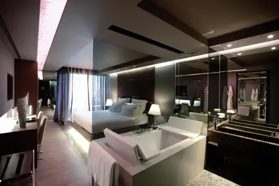 a hotel room with a bed and a bathroom with a sink at The Vine Hotel in Funchal
