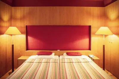 two beds in a hotel room with two lamps at Apartamentos Turisticos Atlantida in Funchal